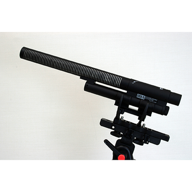 This is a photo of the Sanken CSS-5 microphone. It is shown at an angle on a side view. It is being held in place by a separate piece of black equipment
