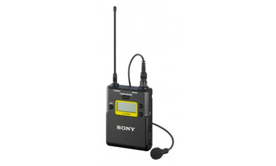 This is a photo of the SONY UTX-B03. It is a transmitter that you plug a microphone in to. It is black in colour with a screen on the front. It has an antenna coming off the top and a small microphone of the side. It is at a front facing view. 